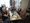 Eine Gruppe fröhlicher Senioren sitzt in einem Restaurant an einem Tisch und klatscht begeistert Beifall. Auf dem Tisch stehen Getränke und Besteck.
